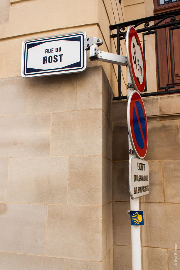 A street name plate is mounted to a column